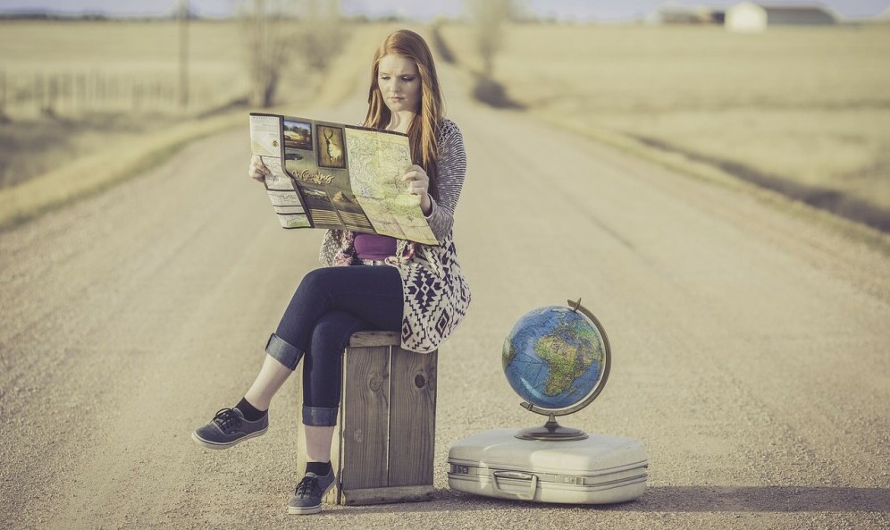 women on road with globe and map